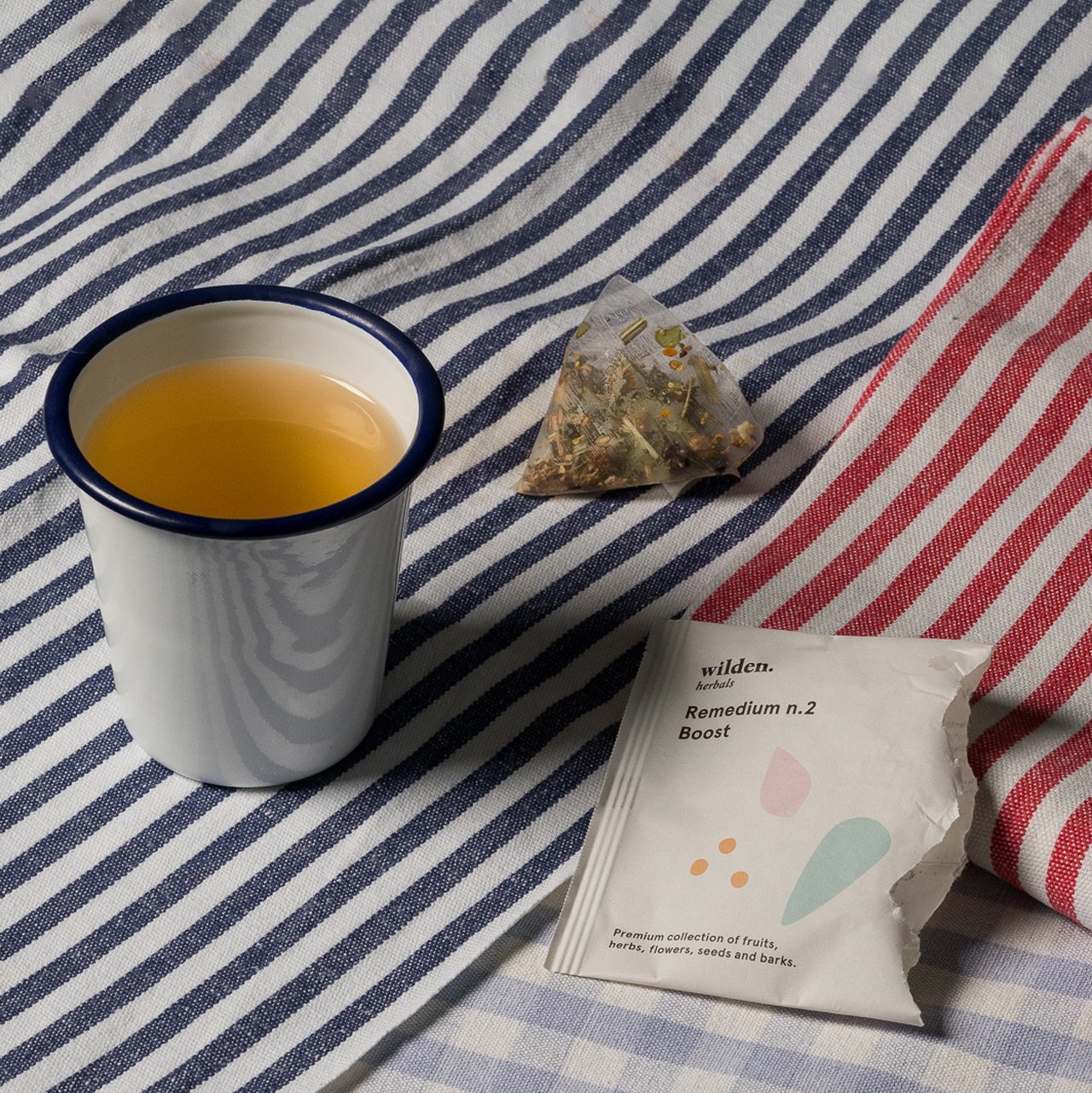 Taza simple de infusión de hierbas orgánicas con telas de patrón de líneas.