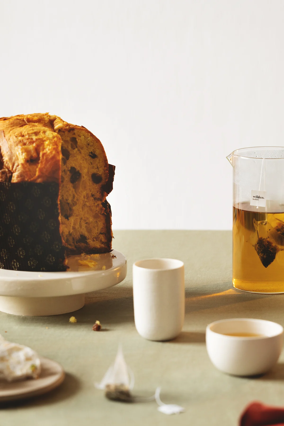 Tavola di Natale con panettone e caraffa di tisana Wilden
